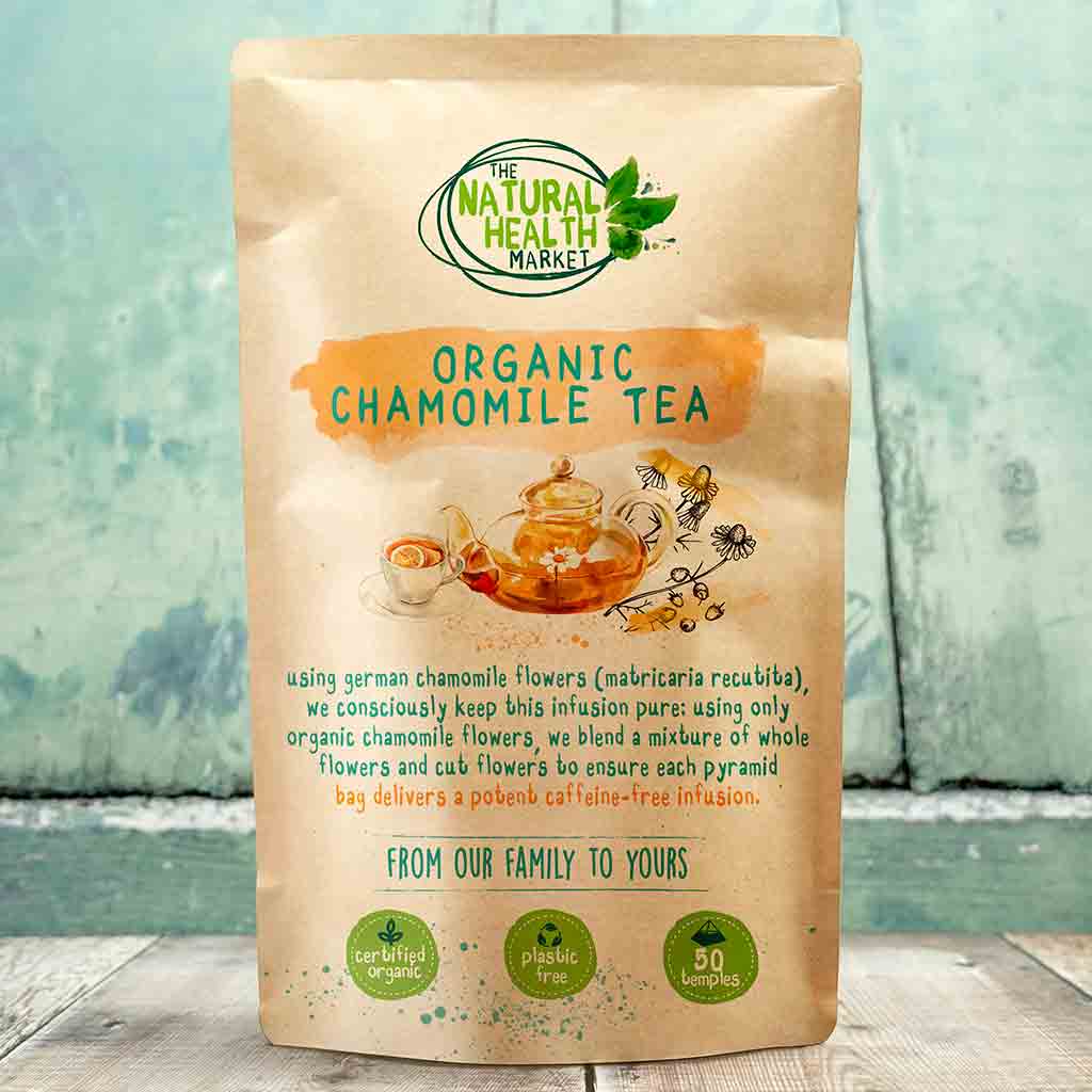 Bag of Organic Chamomile Tea from The Natural Health Market on a wooden surface with a blurred green background.