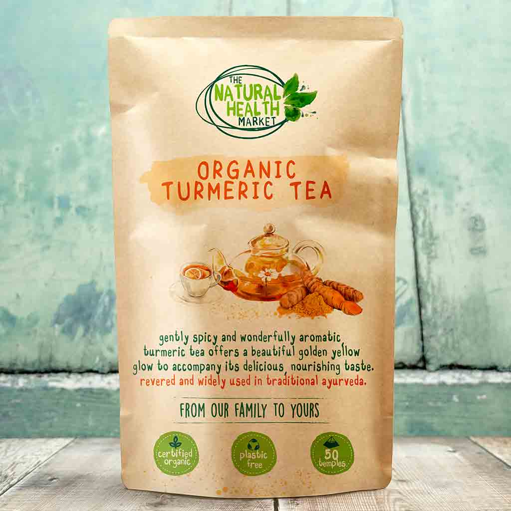 Bag of Organic Turmeric Tea from The Natural Health Market on a wooden surface with a light blue background.