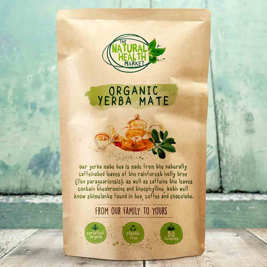 Bag of Organic Yerba Mate from The Natural Health Market on a wooden surface with a light blue background.