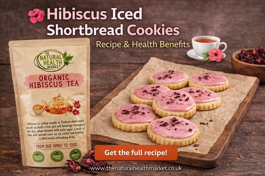 Pouch of Hibiscus tea next to a board with seven cookies iced with pink hibiscus icing