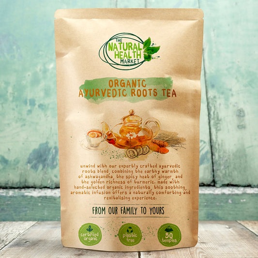 Organic Ayurvedic Roots Tea Bags package from The Natural Health Market with text and graphics on a wooden surface.