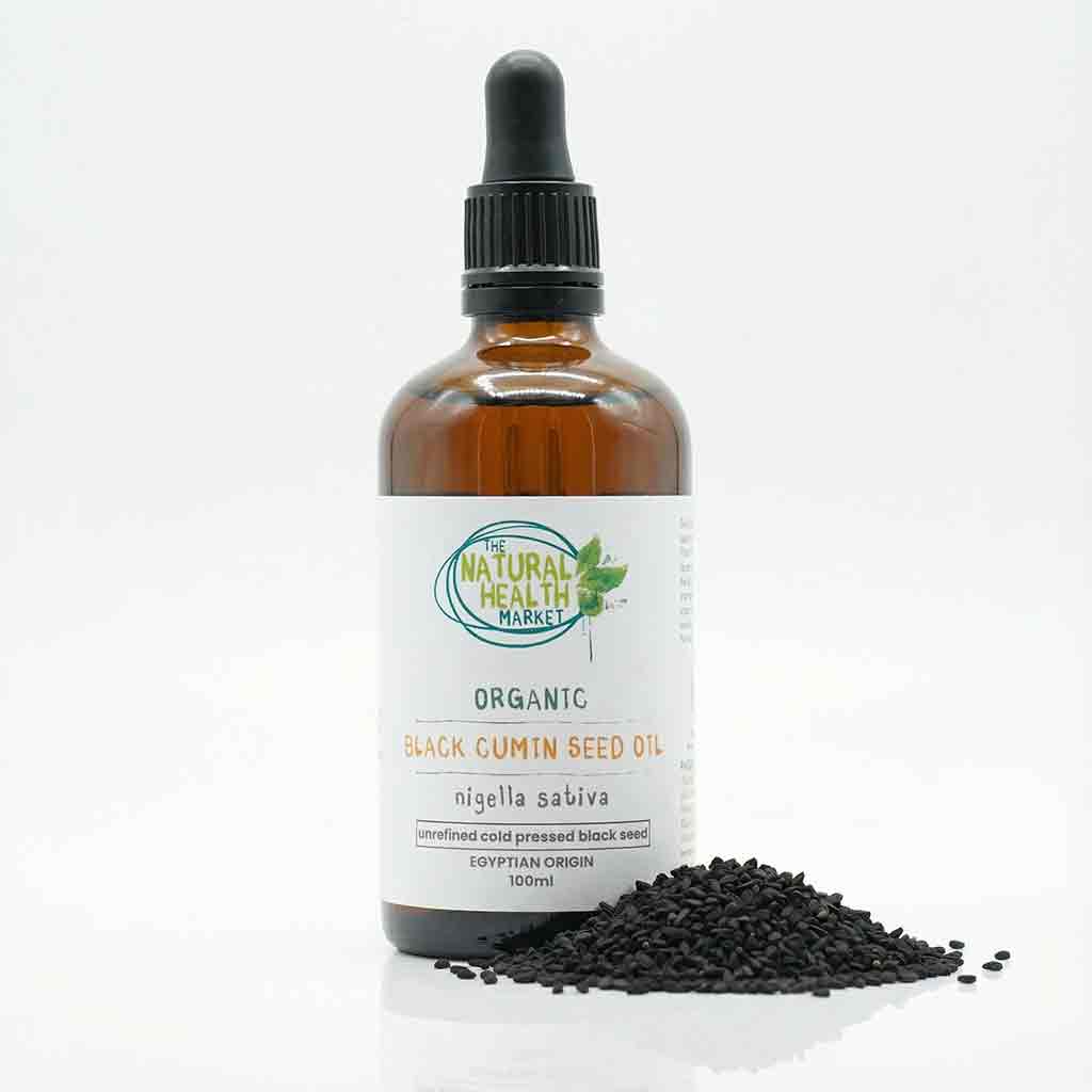 Bottle of organic black cumin seed oil with seeds on a white background