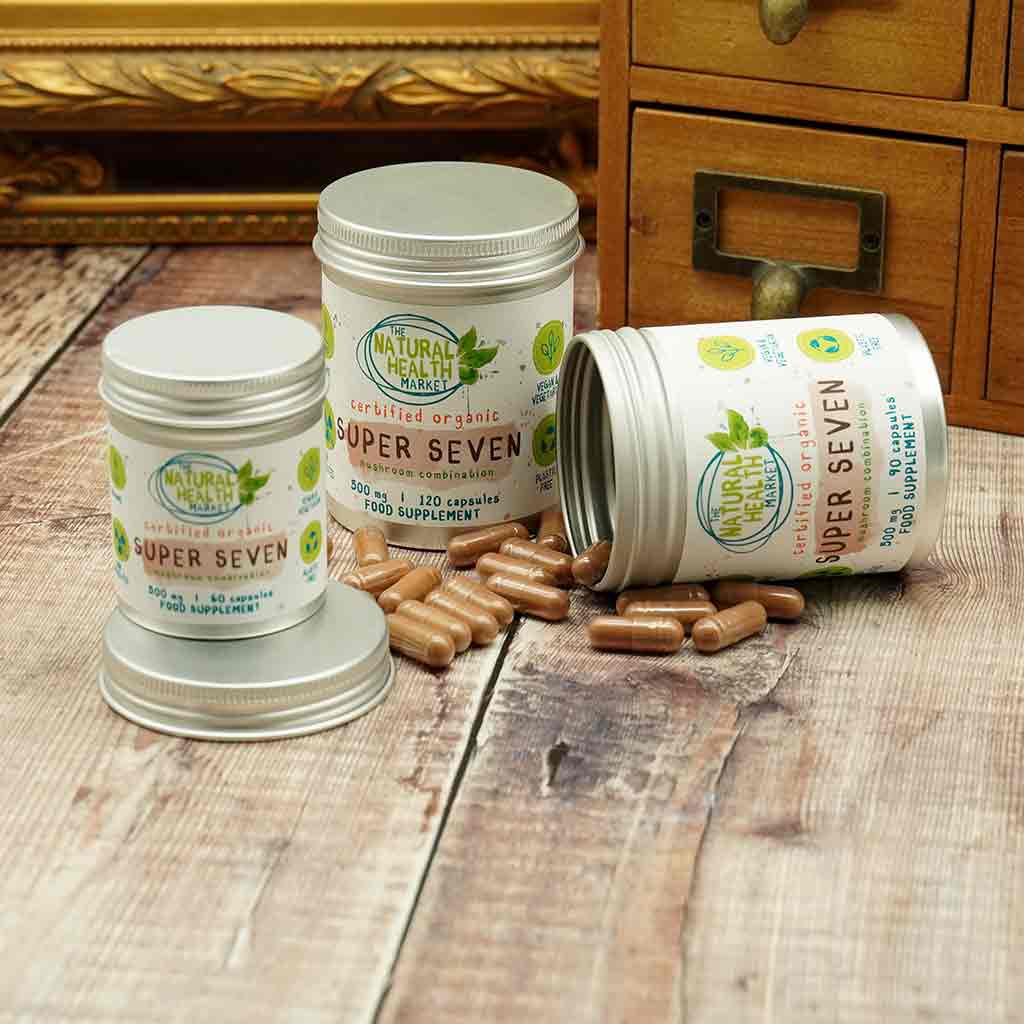 Organic Mushroom Complex Capsules open on a wooden floor showing capsule size.