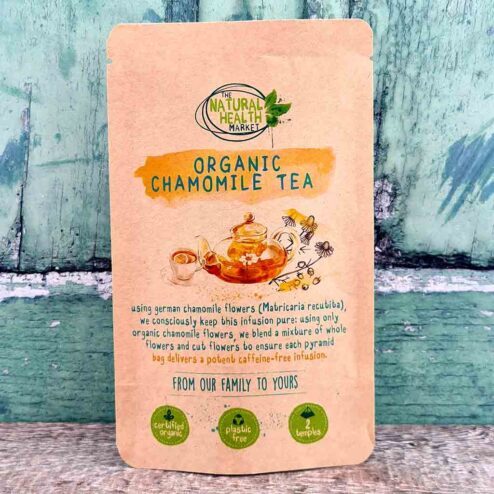 Organic chamomile tea 2 tea bag pack on a rustic wooden board.