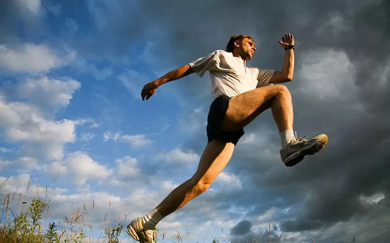 A runner jumping over the camera.