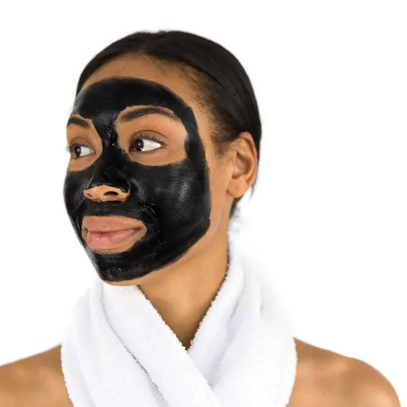 A lady with a charcoal face mask on.