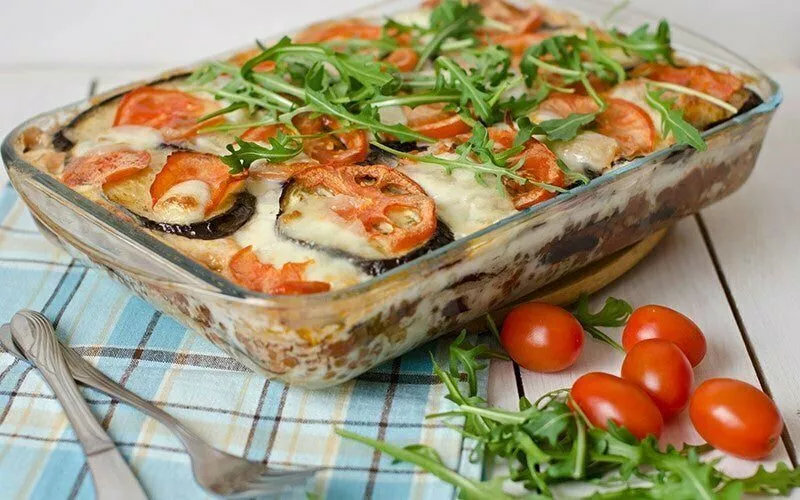 A vegetable moussaka in a Pyrex dish with a side salad.